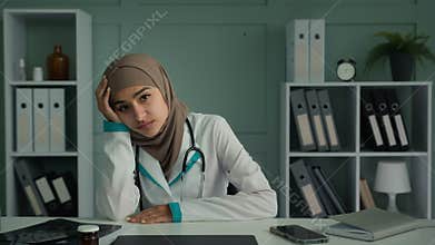 Bored unhappy thoughtful woman muslim doctor intern sit at office clinic feel sadness desperation mental disorder think