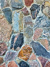 Colorful old stone wall texture background. Background of stone wall of boulders and pebbles. Stone in the beside of house. Black