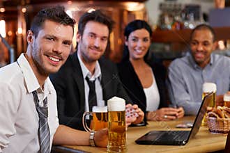 Young office worker drinking beer at pub