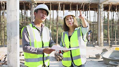 Civil engineer and construction worker manager holding digital tablet and blueprints , talking and planing about construction site