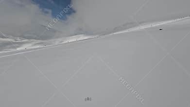 FPV drone low dynamic flight over snow field to group people extreme climbers