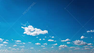 White Fluffy Clouds Slowly Float Through the Blue Daytime Sky Timelapse