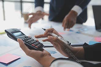 Financial analysts analyze business financial reports on a digital tablet planning investment project during a discussion at a