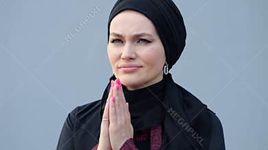 Woman in hijab prays for better life in Muslim country