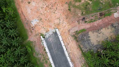 Aerial view the end of asphalt road near red clay soil