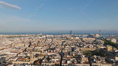 Forwards fly over Catalan flag on top of tower above city. Senyera flying in light wind. Barcelona, Spain
