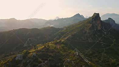 aerial scenic landscape with green fields, meadows, curved mountain river and mountain ridge with high mountains and