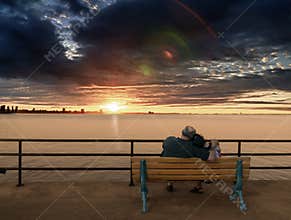 Older couple on bench enjoying Sunset