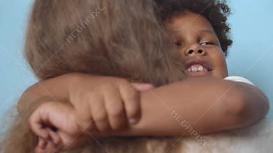 Happy orphan African-American boy hug adoptive mother. Realtime