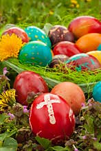 Colorful easter eggs with flowers, outside. Red egg with a cross