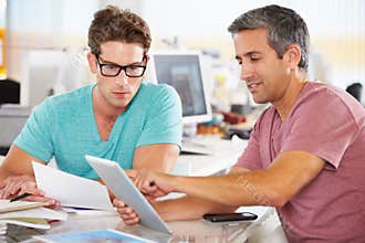 Two Men Using Tablet Computer In Creative Office