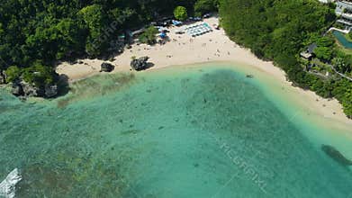 Padang Padang beach in Bali with resorts and turquoise ocean. Aerial drone view