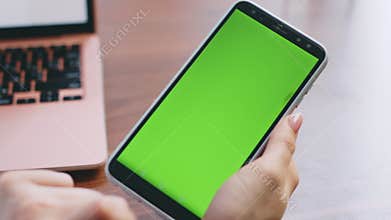 Girl hands swiping green screen telephone looking phone number in office closeup