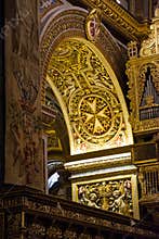 Detail of the gold decorated arch with the Maltese eight-pointed cross in Valletta Cathedral, Malta