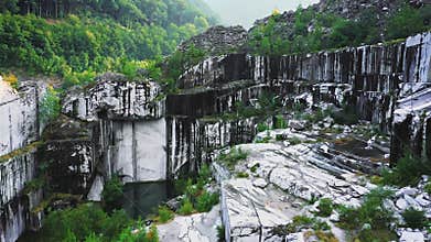 Drone fly down and pan in abandoned white marble quarry in Carrara, Italy.