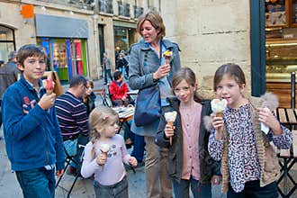 Happy family with ice cream. Ice cream in the shape of a flower proudly presented by a happy mother with four children .