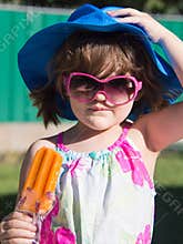 Young Toddler Girl Eating Orange Popsicle in Summer