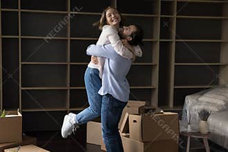 Excited overjoyed young married couple celebrating moving, house buying