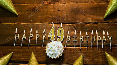 Happy birthday 49 golden letters of the candle with the number happy birthday, the background of the pie with candles
