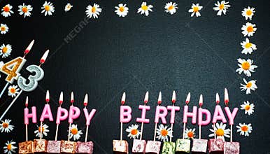 Happy birthday background with number  43. Copy space. Pink happy birthday candles on a black background. Happy birthday flower fr