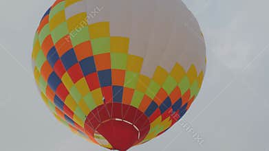 Colorful hot air balloon flying against grey winter sky