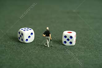 Miniature people toy figure photography. Gambling play concept. A men golfer standing in the middle of two dice