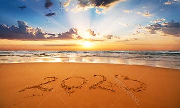 Happy New Year 2023 concept, lettering on the beach. Written text on the sea beach at sunrise