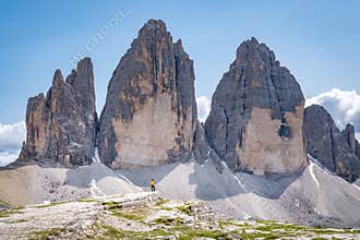 Young female is admiring Tre Cime di Lavaredo in Dolomites mountains in Italy