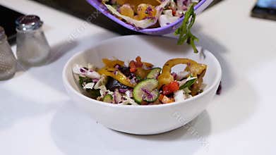 Healthy food concept arugula or salad mix with vegetables. Pour fresh salad into a bowl. Sweet pepper salad mixed