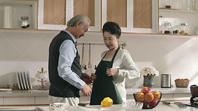 senior asian man tying up apron for wife