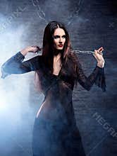 A young and witch in dark erotic clothes