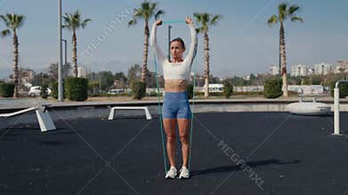 Woman making shoulder workout with rubber bands. Be H3althy.