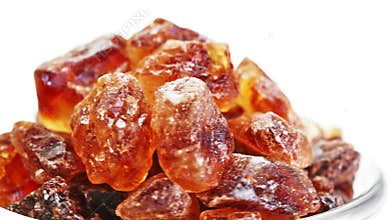 Brown lump cane sugar heap rotating