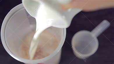 Man's hand tossing a scoop of chocolate whey protein