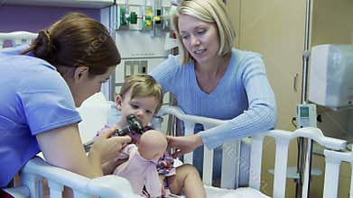 Mother And Daughter With Staff In Pediatric Ward Of Hospital