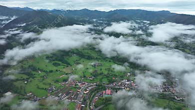 Aerial view of lush countryside with village, forest, and mountains, Infiesto, Asturia, Spain.