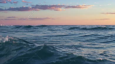 Ocean Waves Crashing at Sunset with Pink Clouds in the Evening Light