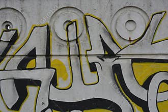 A bright,The graffiti depicting the word in Russian KASHAU, ????? is painted on a white and gray concrete fence.