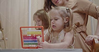 Family Time at Home: Mother and Daughters Enjoy Quality Time Together While Learning with an Abacus