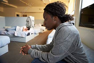 Women Sitting On Beds In Homeless Shelter