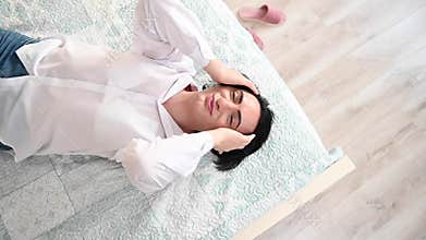 Top view of man flirting with camera while lying on bed.
