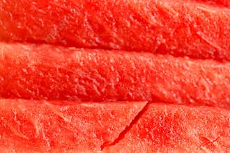 Freshly sliced watermelon showcasing vibrant red fruit and textured rind during summer season
