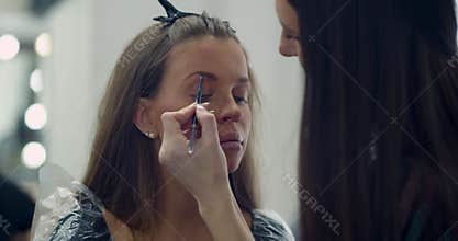 Makeup. Brow contouring. Preparation of a young beautiful woman for party.