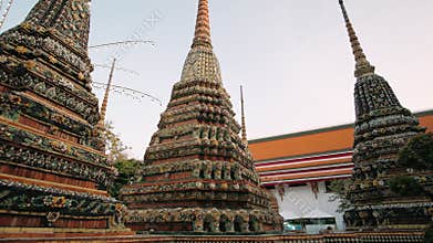 Colorful buddhist stupas, highlighting ornate architectural details of historic Wat Pho Temple complex in Bangkok