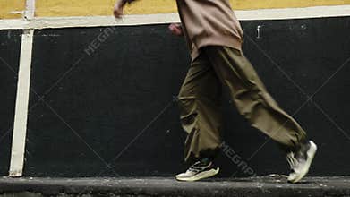 Beautiful gen z young woman dancing contemporary dance against urban wall