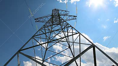 tall electric masts against sun and cloudy sky - timelapse