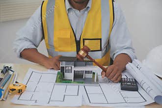 Judge gavel on building blueprint plans with a yellow safety helmet in the background. law that deals with matters relating to
