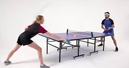 Playing table tennis, man and woman competing in intense match indoors