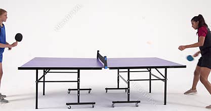 Competing in table tennis, two people playing in studio setting