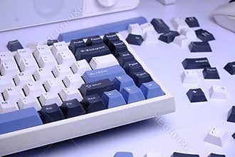 Close Up Modern 75% Layout Mechanical Keyboard with White, Blue, and Black Keycaps on a Clean White Desk